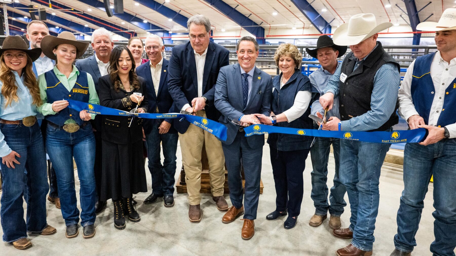 A large group of people posing for a ceremonial ribbon-cutting photo.