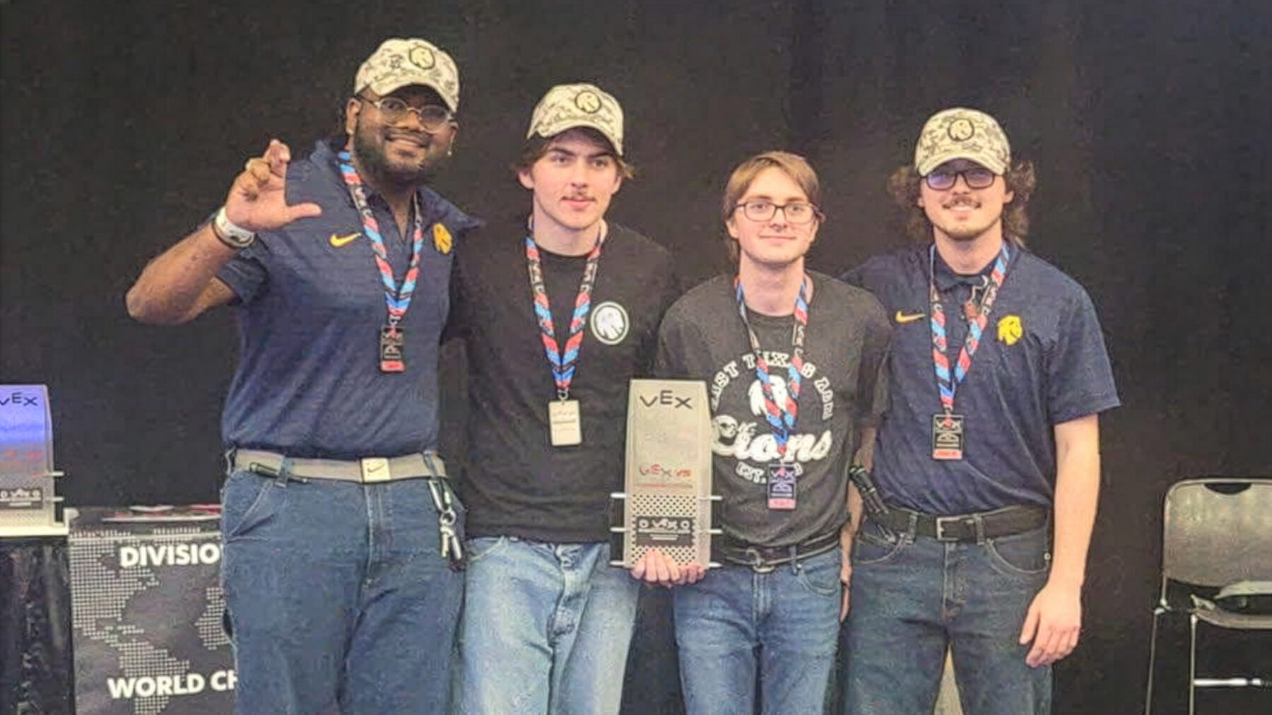 A group of four people posing with a trophy