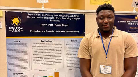 Man standing next to a poster board.