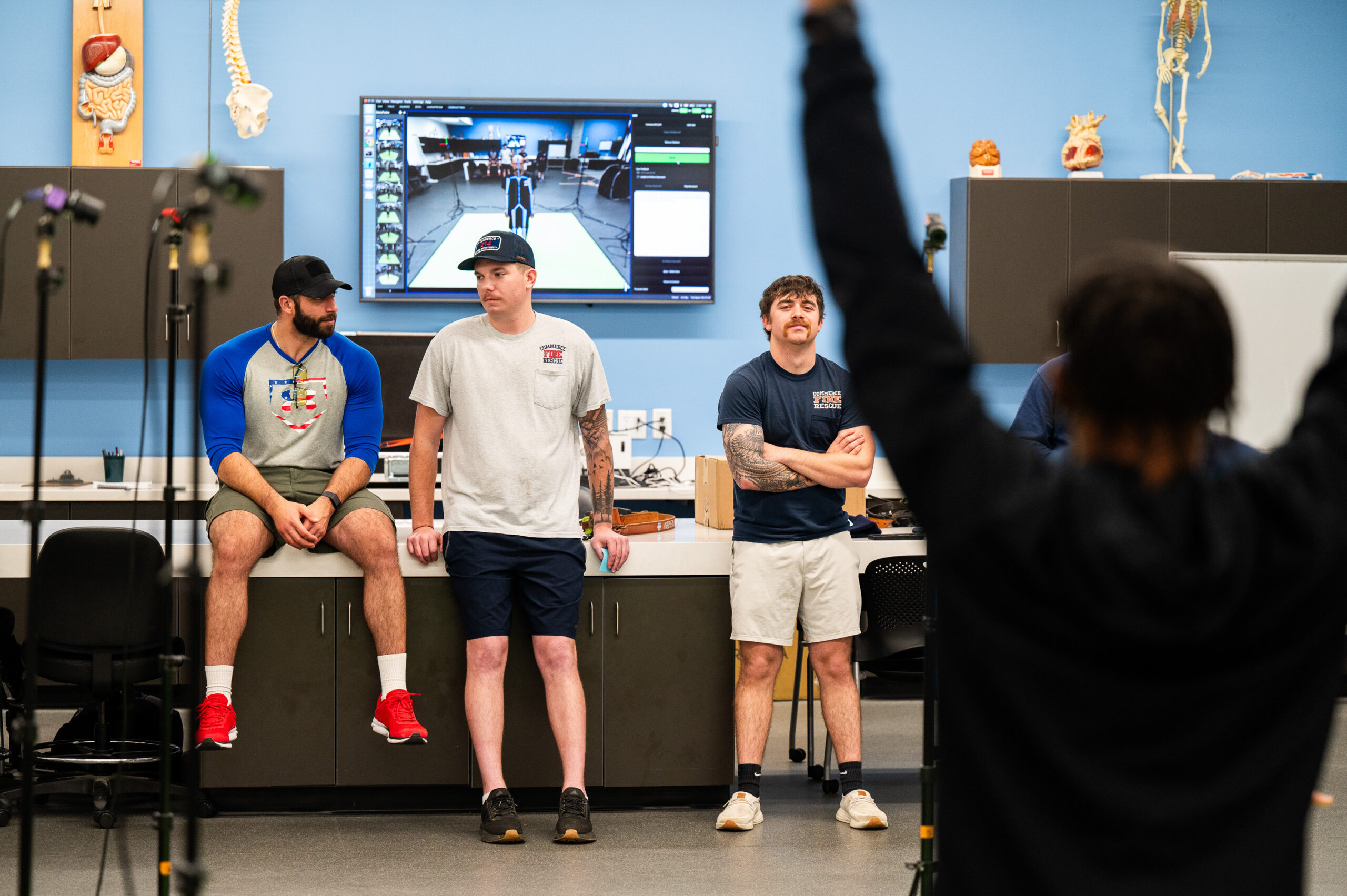 3 individuals watching another person performing a exercise. 