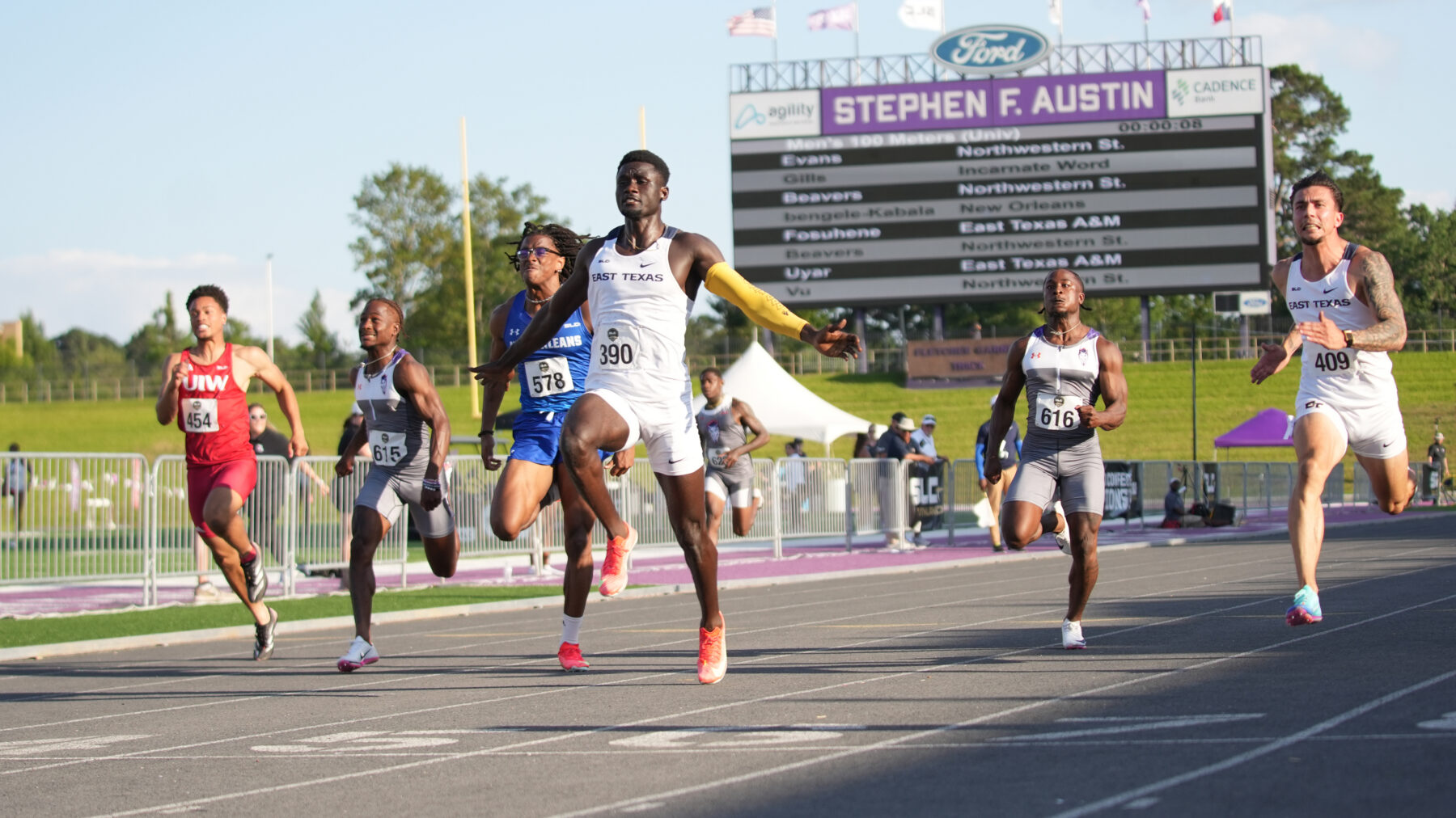 A group of track athletes running in a 100 meter dash competition.