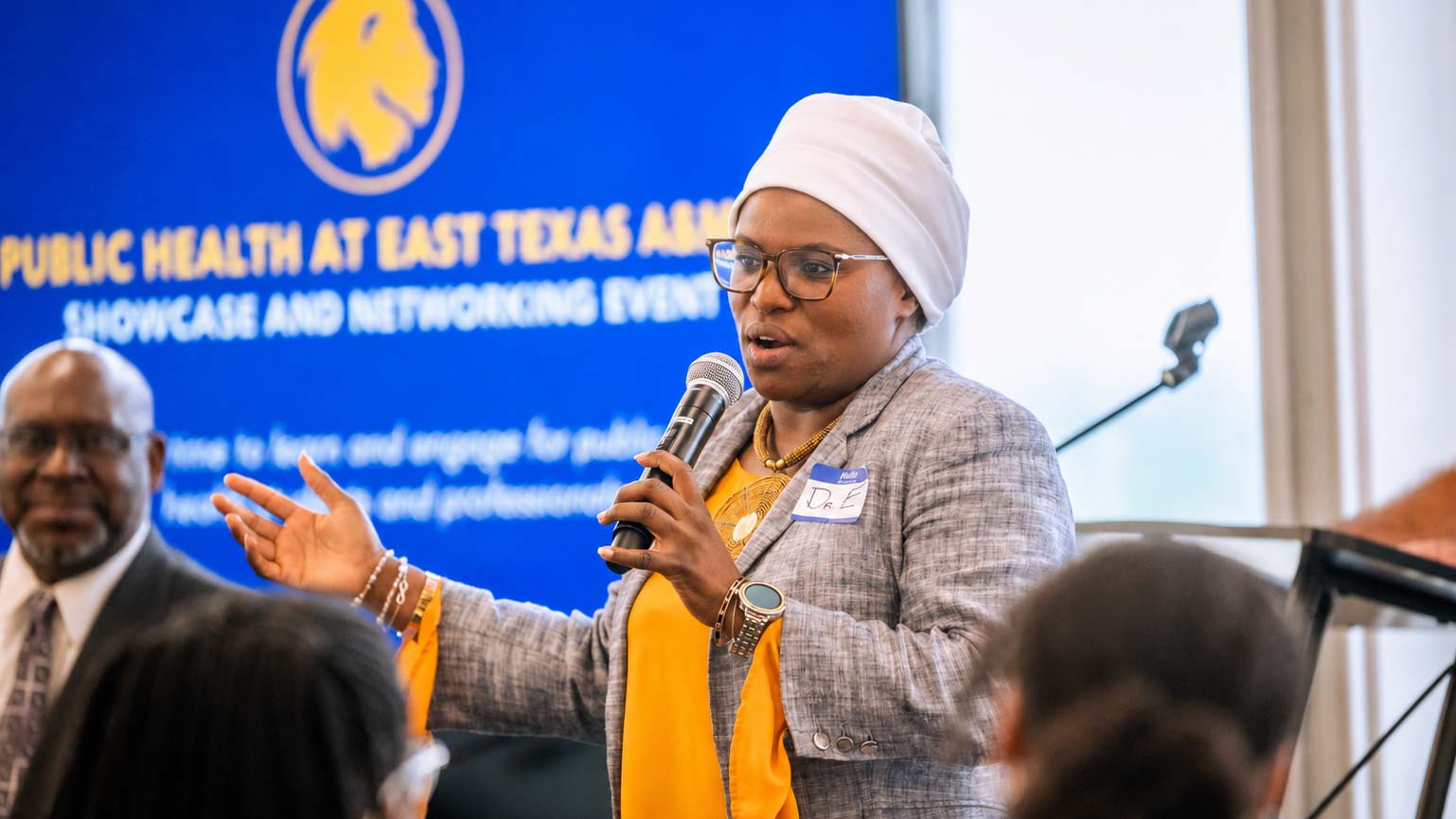 A woman speaks into a microphone.