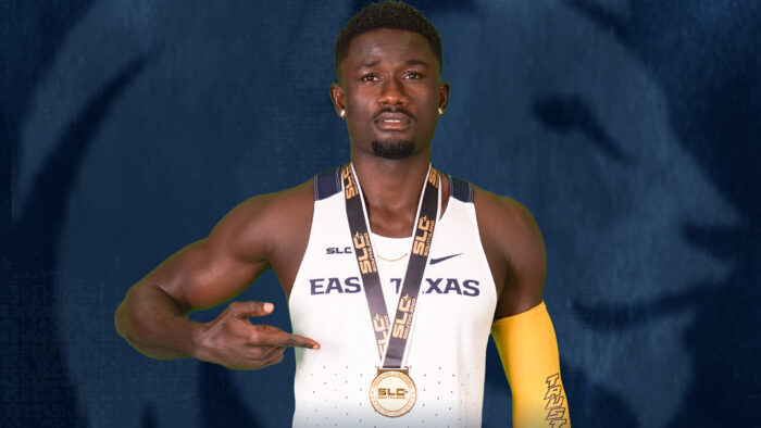 A track and field runner posing with a gold medal