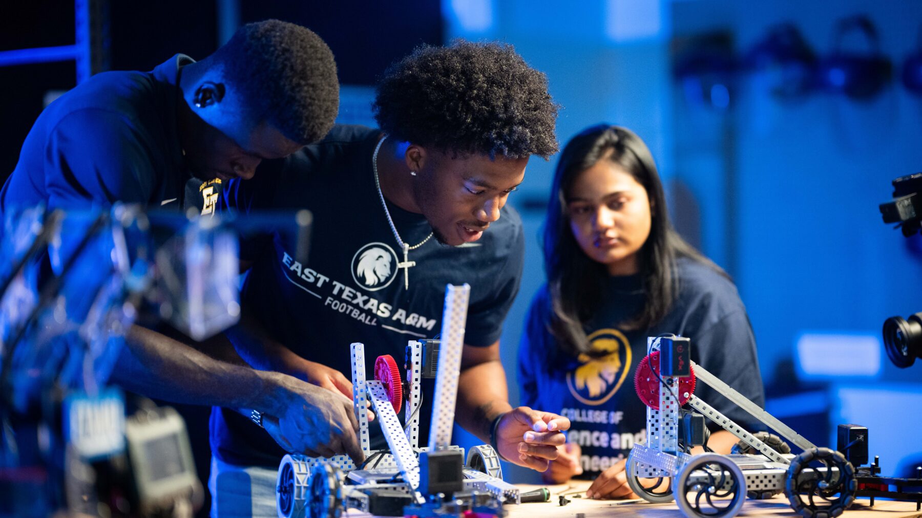 Three young people work on mechanical objects.