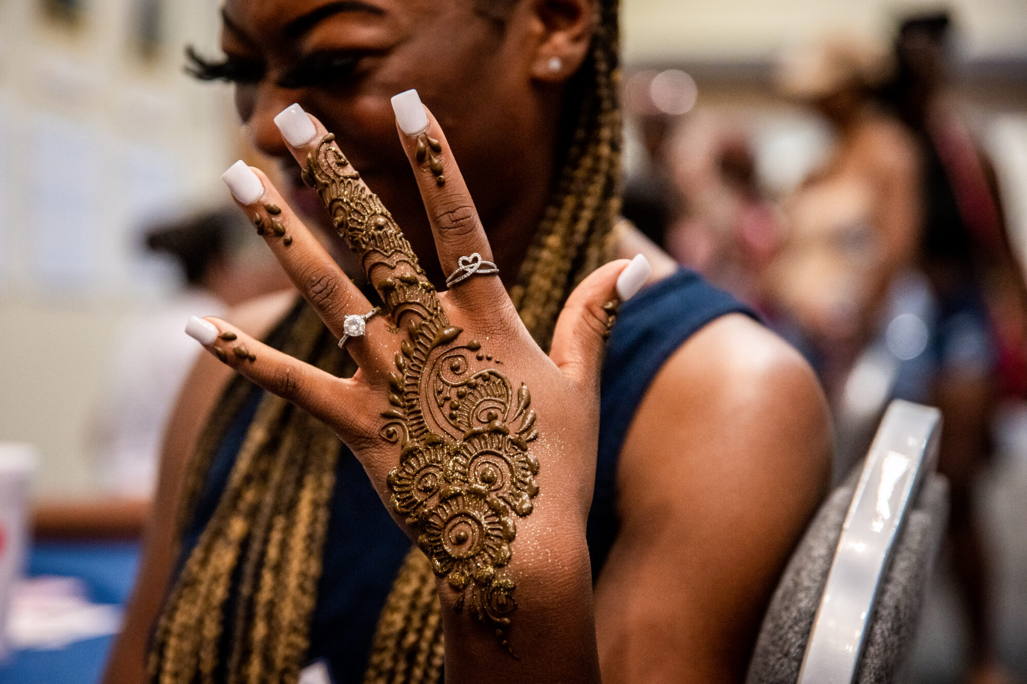 person holding up her hand which has a henna tattoo on it