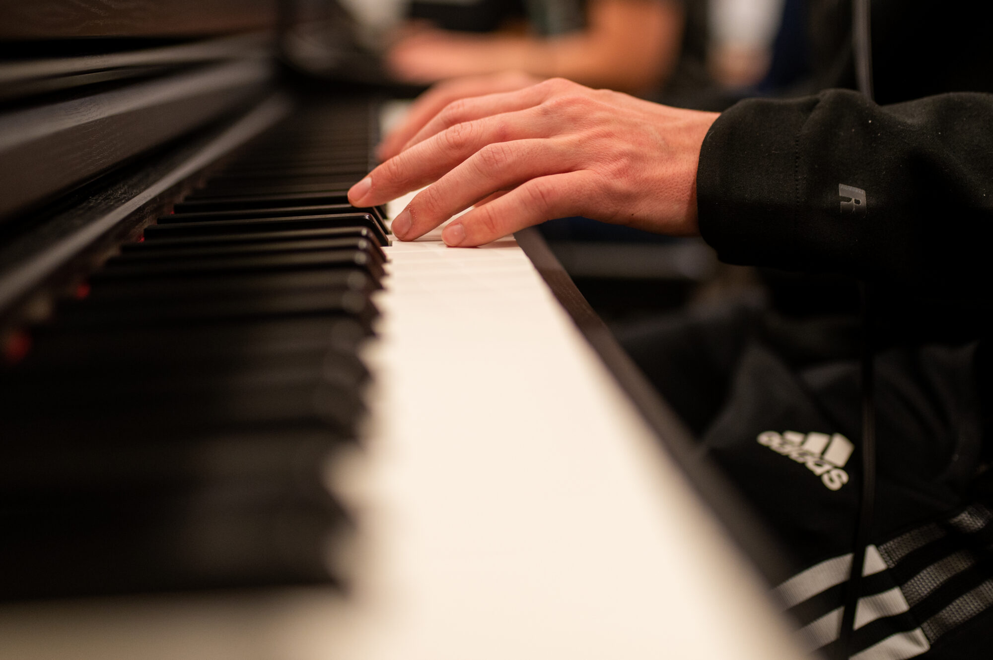 closeup of hand playing piano keys