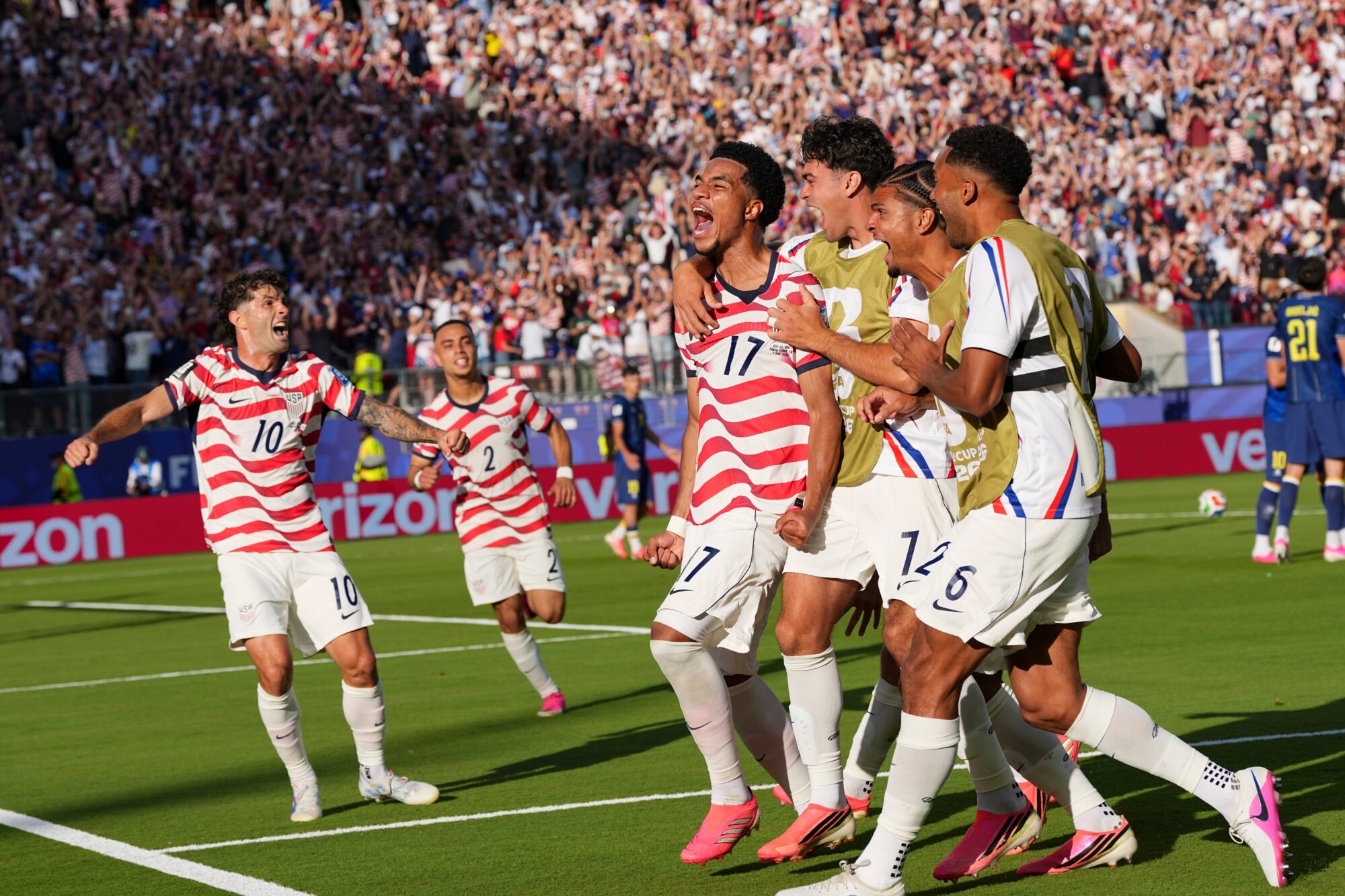 Soccer players celebrate after scoring a goal.