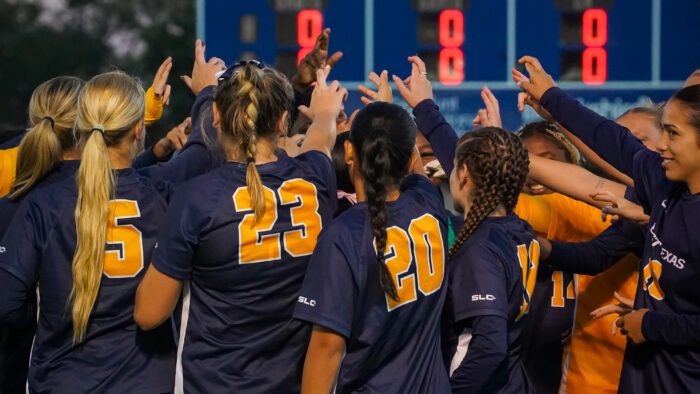 A soccer team in a huddle before a match