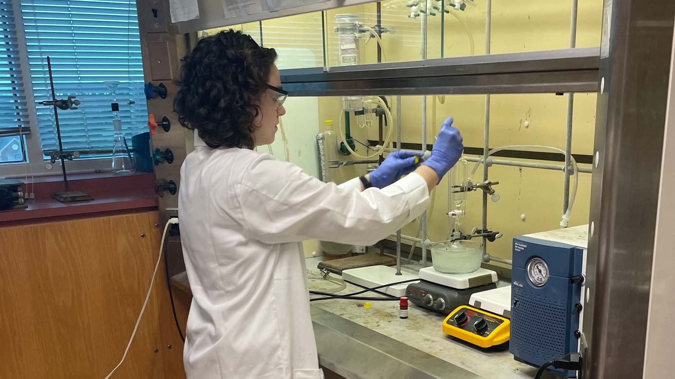 A woman in a lab coat messes with some sciency stuff.