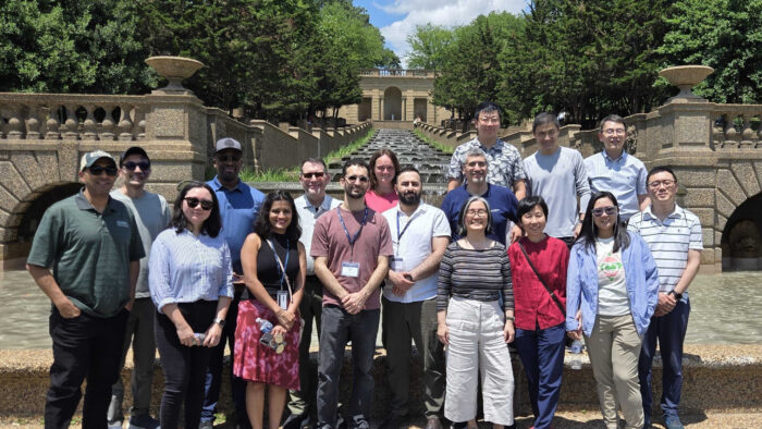 A group of people posing for a photo on a college campus.