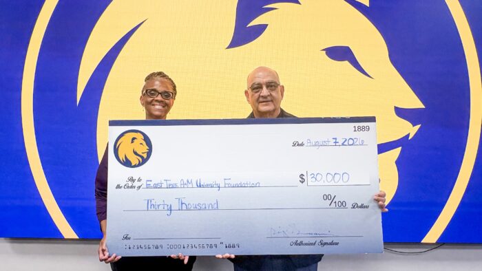 Two people holding a large ceremonial cheque.