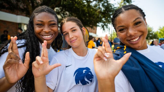 Three people posing close together for a photo.