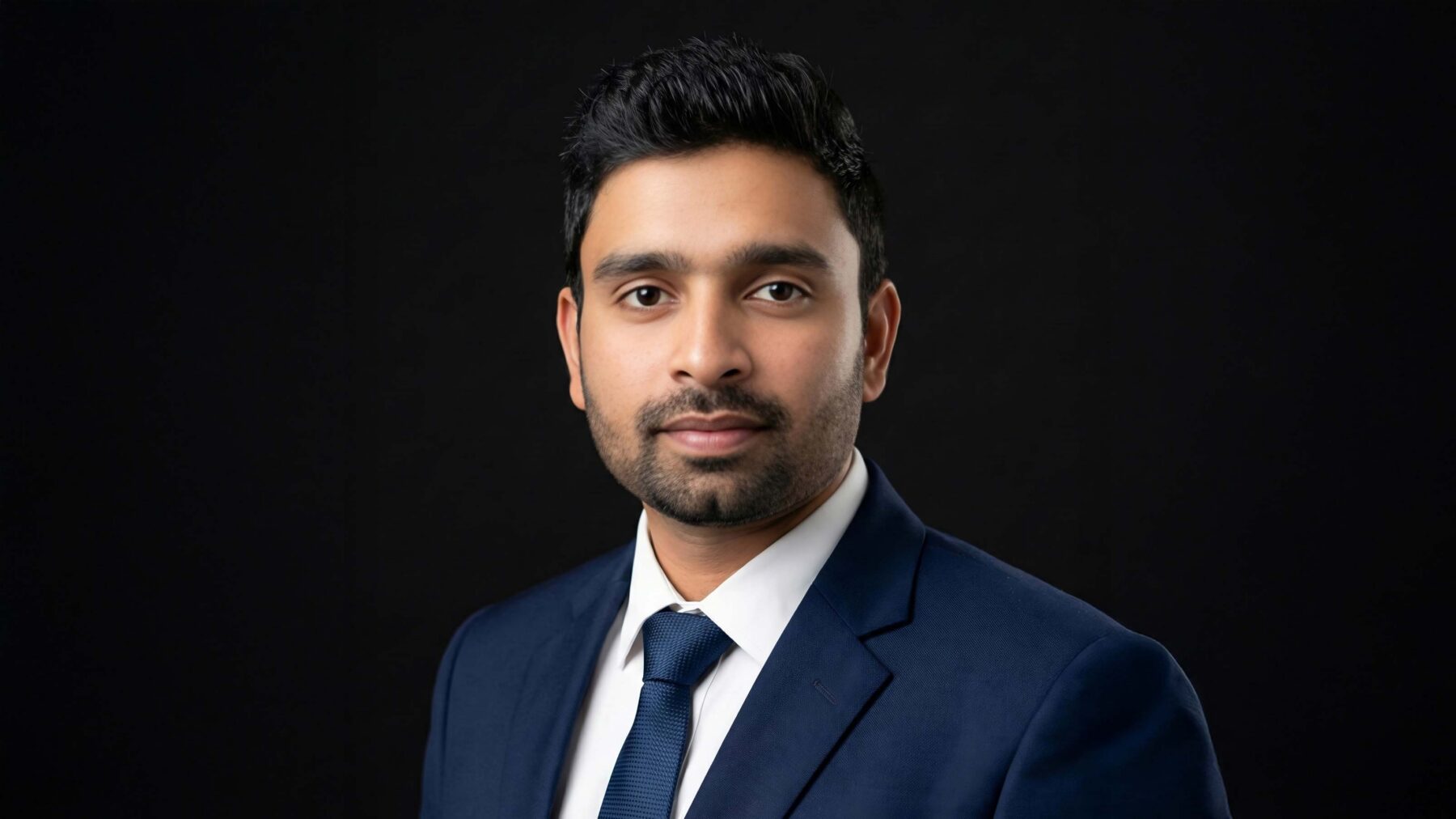 Headshot of a man, black background.