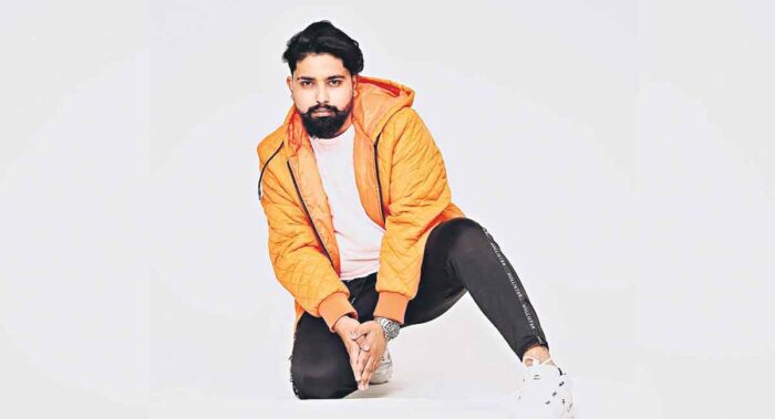 A photoshoot of a person in a hoodie in front of a white background.
