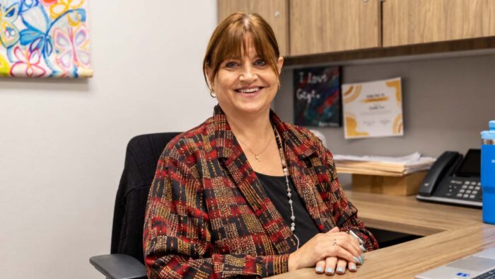 Woman sitting at a desk smiling.