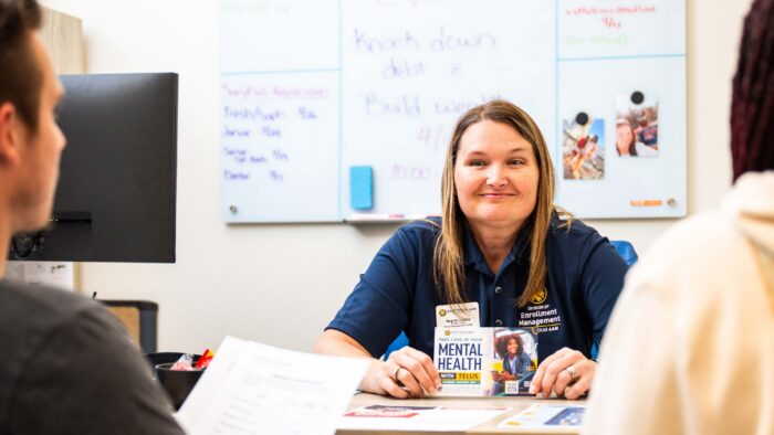 A woman sitting at a desk smiling.