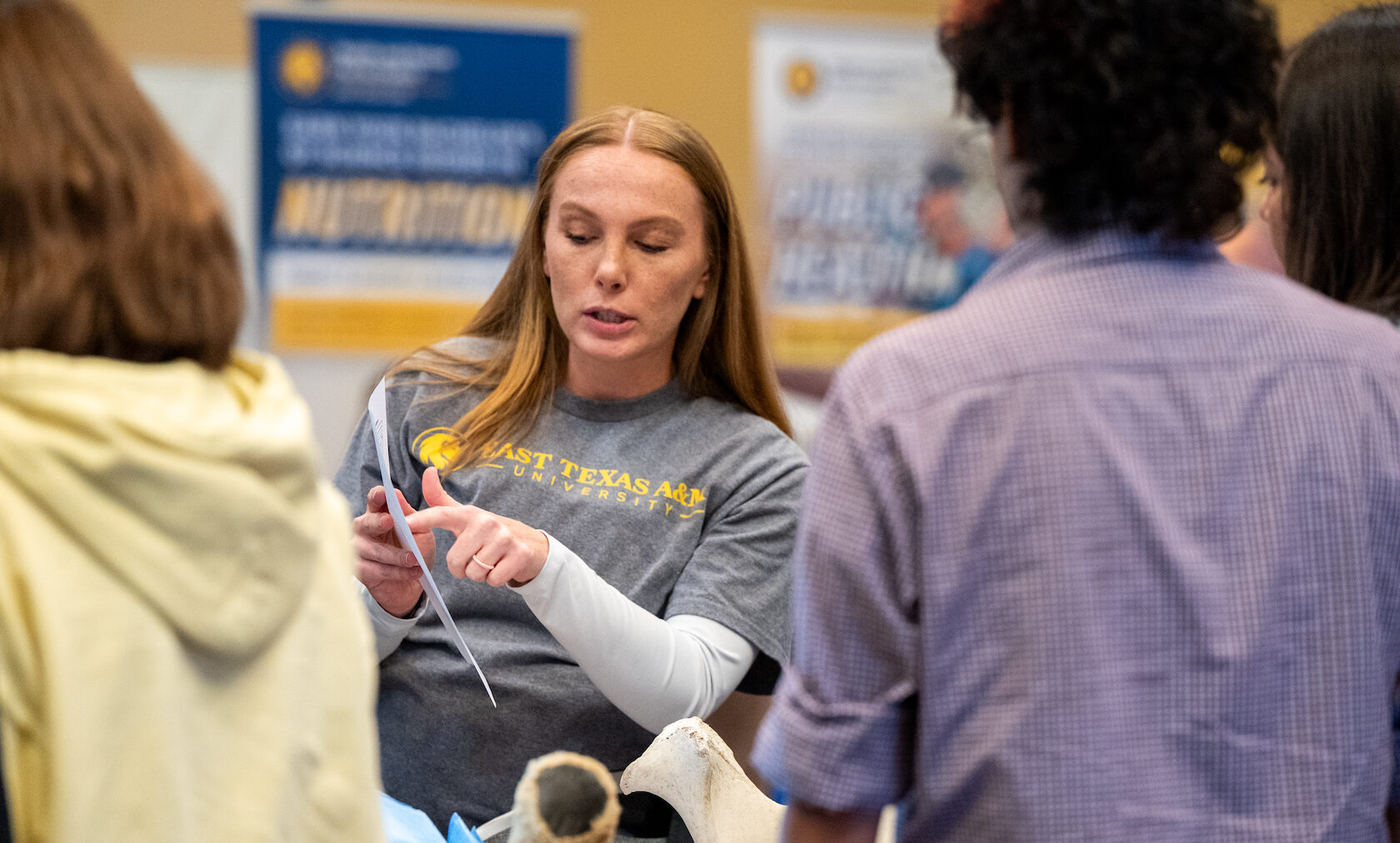 A person at a college fair answering questions.