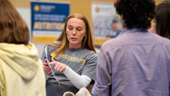A person at a college fair answering questions.