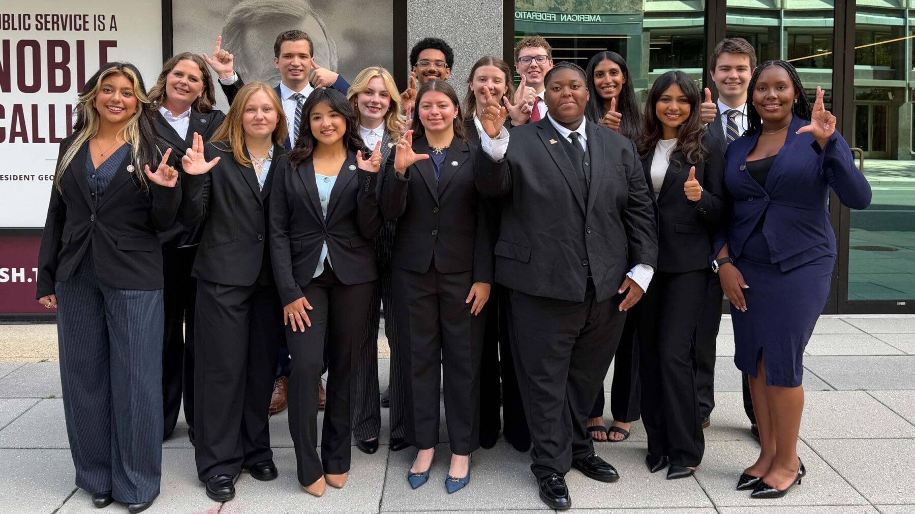 A group of young adults stand together smiling.